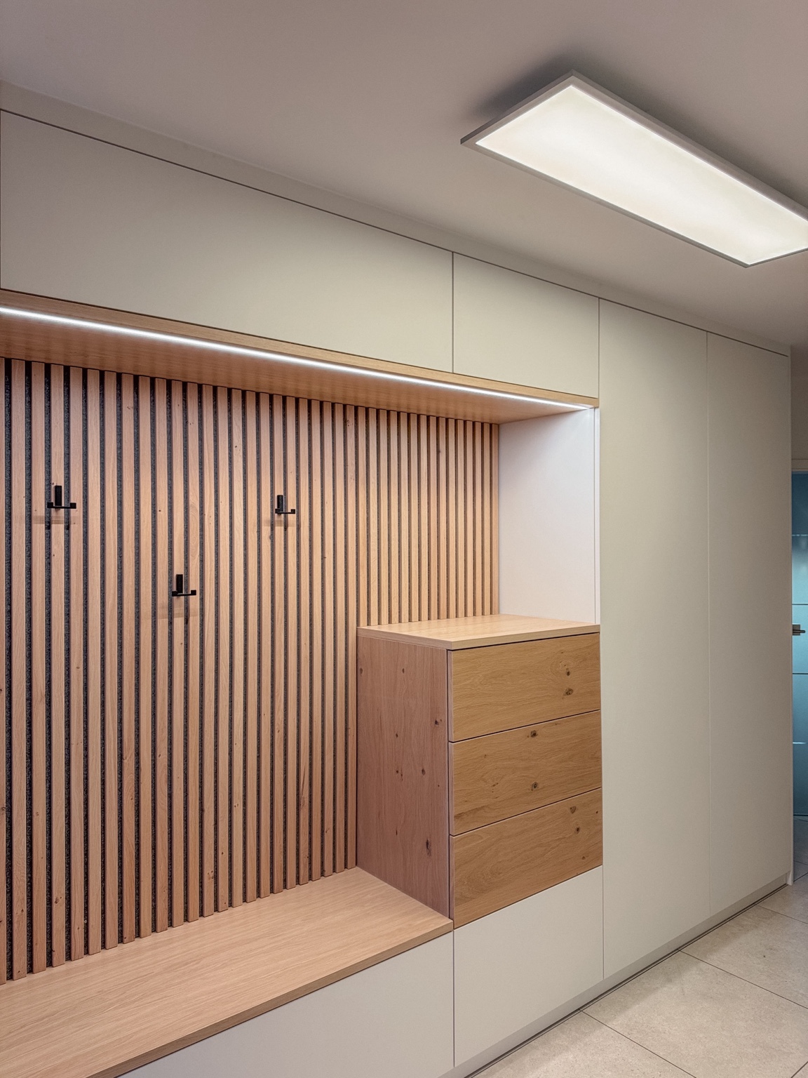 Garderobe mit Eiche-Lamellenwand und Sitzbank